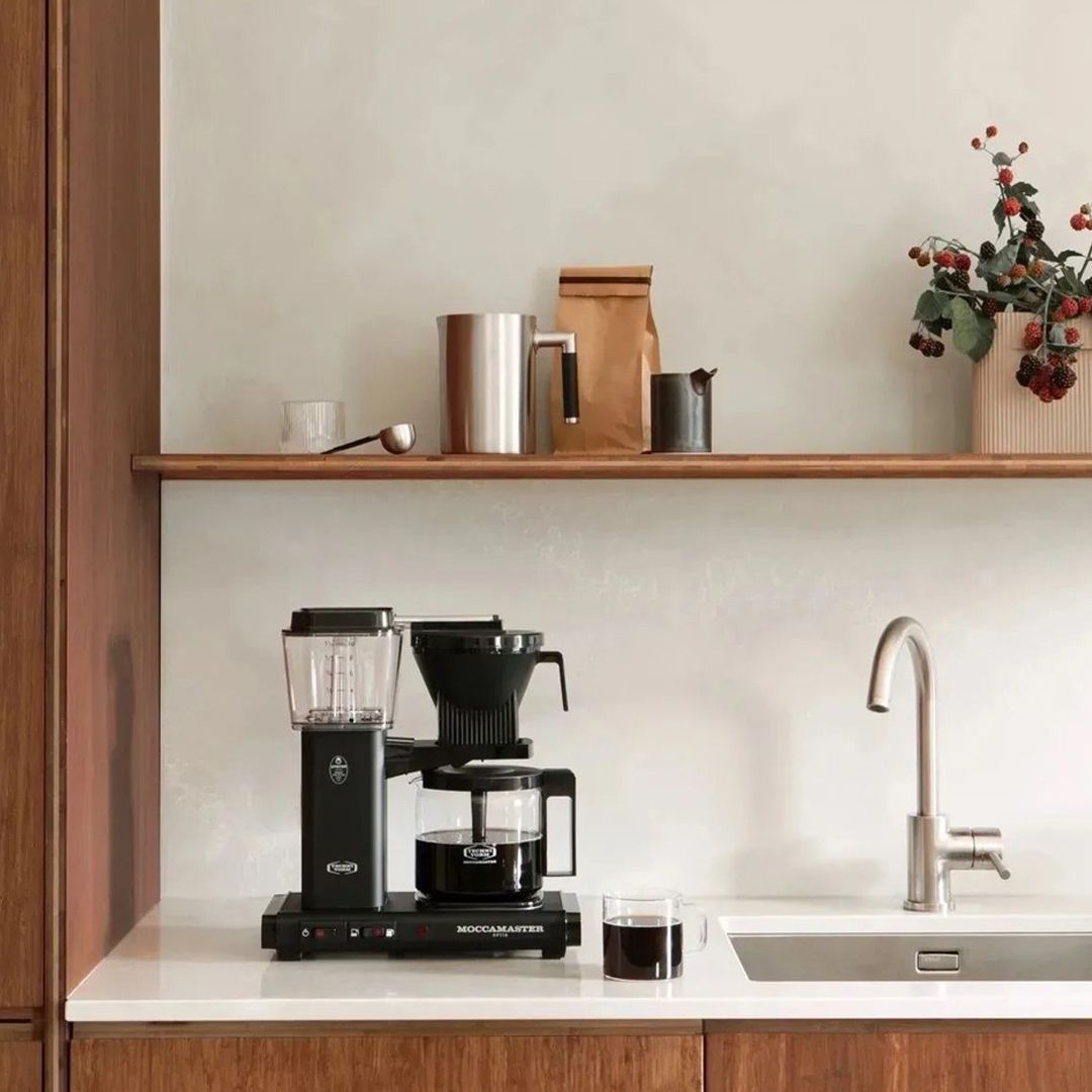 Image of coffee machine on white stone bench with sink