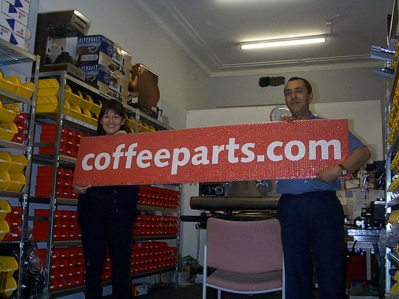 Dom and Cilinia Holding Coffee Parts Sign